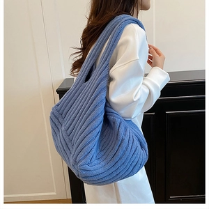 Detailed knit texture of bright blue oversized shoulder tote bag with vertical stripes