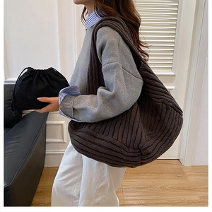 Detail of a brown knit hobo tote bag with rib-knit texture and inner drawstring pouch