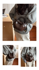 Detail of dark brown leather dumpling bag with gold ball hardware and pleated design