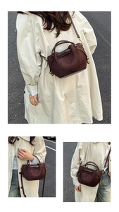 Detail of dark brown suede bucket bag with drawstring and golden bead metallic pendant