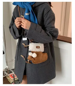 Detail of boot-shaped plush crossbody bag with faux fur trim and cute pom-poms