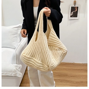 Detail of cream knitted tote bag showing vertical ribbed texture and soft fabric
