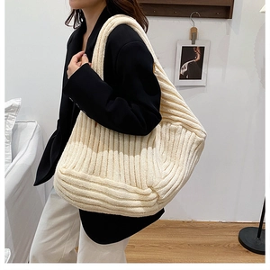 Creamy white oversized knitted tote bag with ribbed texture for a minimalist casual look