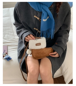 Detail of cute brown faux suede boot-shaped bag with white plush fur and pompom trim