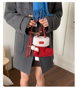 Detail of Christmas stocking plush crossbody bag with white fur trim and pom-poms