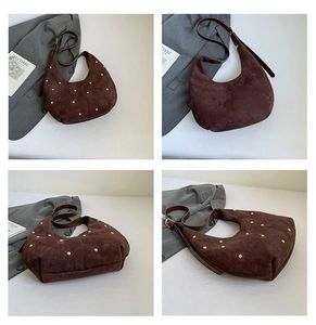 Detail view of brown suede moon bag featuring gold rivet studs and adjustable strap