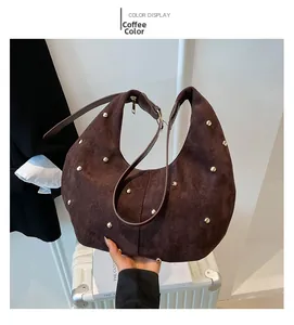 Detail of coffee brown suede Hobo bag featuring vintage gold round studs and wide strap