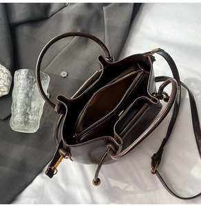 Interior layout of dark brown leather handbag with zipper pocket and metal hardware