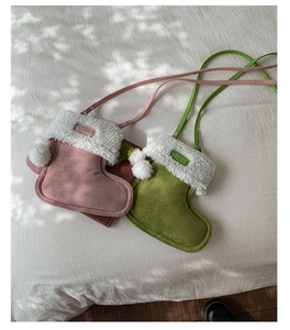 Detail of plush Christmas stocking mini crossbody bags in pink and green colors