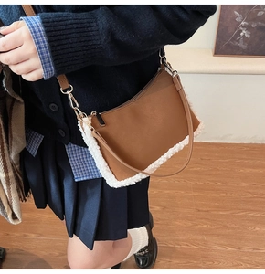 Détail du sac bandoulière en similicuir marron avec bordure en sherpa blanc et zip doré