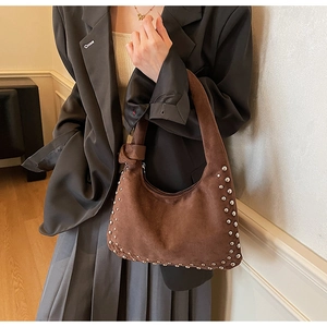 Detail of dark brown suede hobo bag with silver rivets and knotted strap detail