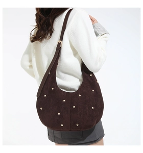 Detail of dark brown suede hobo bag with vintage gold rivets and adjustable strap