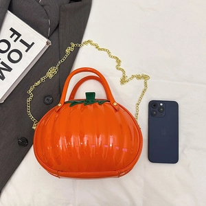 Chic orange pumpkin-shaped handbag with green leaf top and gold chain shoulder strap