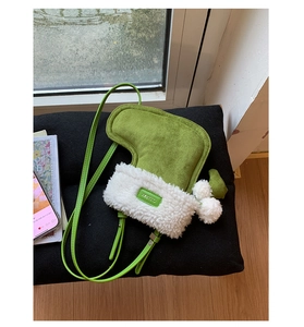 Detail of green suede boot-shaped crossbody bag with white faux fur trim and pom-pom charm