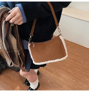 Détail du sac à bandoulière en similicuir marron avec bordure en peau lainée et boucles dorées