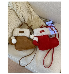 Detail of plush Christmas boot-shaped crossbody bags in brown and red with fur trim