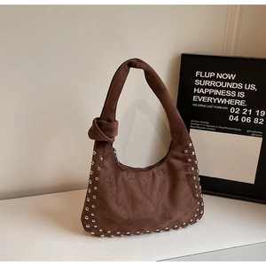 Detail of brown suede shoulder bag with silver rivets and unique knotted strap handle