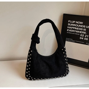 Detail of black suede hobo bag with silver studs and decorative shoulder strap knot