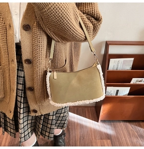 Détail du sac sous l'aisselle en cuir kaki avec bordure en peau lainée blanche et zip
