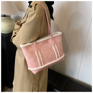Detail of pink faux suede tote bag featuring white shearling trim and golden logo