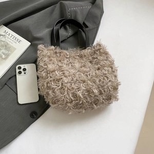 French vintage beige faux fur tote bag with black handles on a grey blazer backdrop