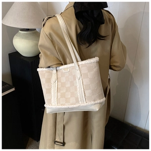 Detail of winter quilted tote bag featuring plush faux fur trim and textured clover pattern