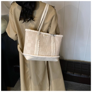 Detail of winter tote bag featuring plush faux fur trim and embossed checkerboard pattern