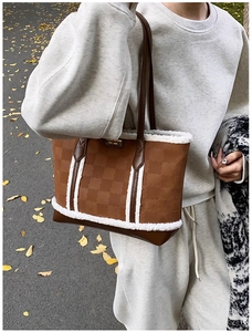 Close-up of caramel tote bag with plush white faux fur trim and textured checkered pattern