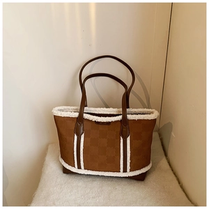 Detail of winter plaid tote bag featuring fuzzy white faux fur trim and leather straps