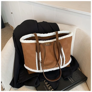 Detailed view of the brown leather tote with plush white faux fur trim on a cozy sofa