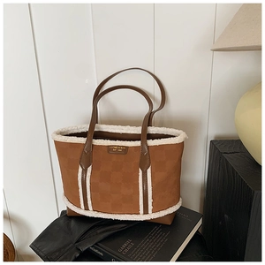 Detail of caramel tote bag featuring white plush trim and embossed floral pattern texture