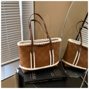 Detail view of brown embossed tote bag with white faux shearling trim and metal logo