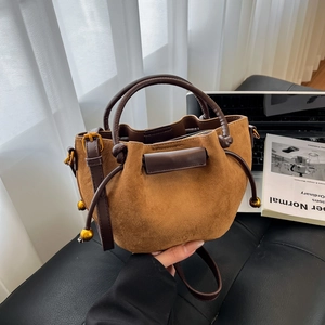 Caramel suede bucket bag with brown leather handles and adjustable shoulder strap