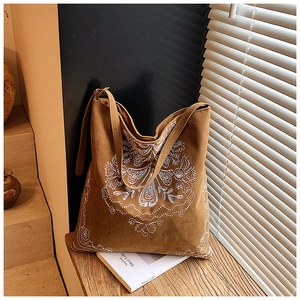 Close-up of caramel vintage tote bag featuring intricate white floral embroidery details