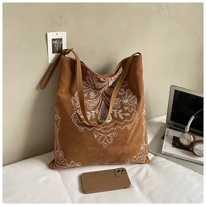 Detail of bohemian floral embroidery on brown faux suede large capacity bucket bag
