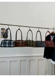 Row of plaid tote bags in five colors hanging on a rack showing vintage texture