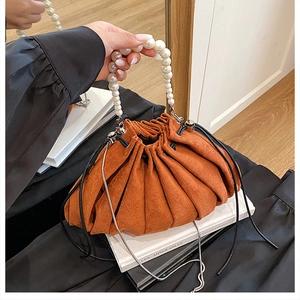 Détail du sac seau plissé orange avec poignée en perles et cordon de serrage