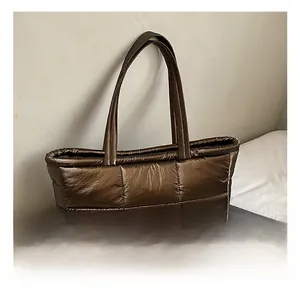 Close-up of brown quilted tote bag with metallic finish and spacious interior details