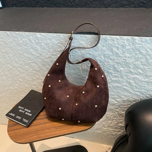 Dettaglio ravvicinato della borsa hobo in pelle scamosciata marrone con borchie dorate