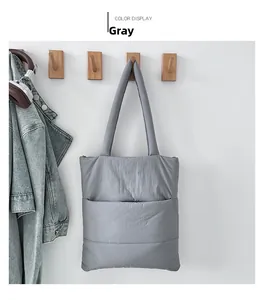 Detail of grey quilted nylon tote bag with front pocket hanging in a home setting