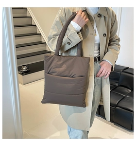 Detailed side view of coffee brown quilted nylon tote bag with puffer padding effect