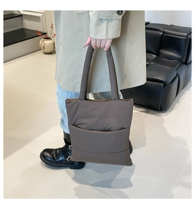 Detailed view of the dark brown quilted tote bag showing its plush texture and large pocket