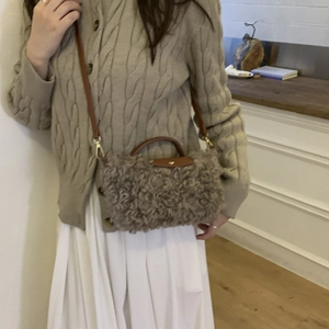 Oatmeal plush crossbody dumpling bag with brown leather handles and gold hardware
