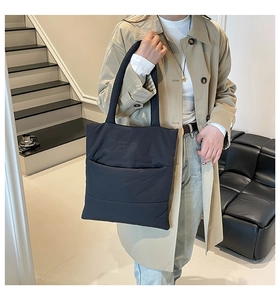 Quilted navy blue tote bag shown in a stylish urban commute scene with high-quality detail