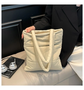 Close-up of cream quilted down tote bag with nylon texture and large capacity for daily use