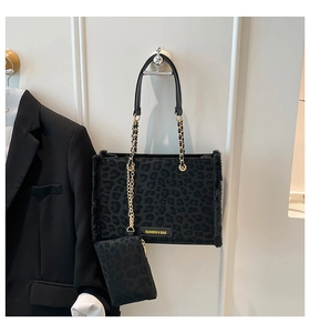 Detail einer Leopard-Print-Tasche mit goldener Kette und kleinem Zusatzbeutel