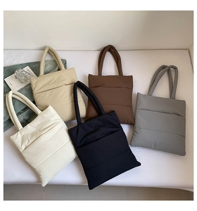 Detailed view of puffer tote bags in five colors with horizontal quilted patterns