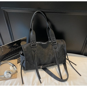 Detailed macro of motorcycle tote bag with long tassels and silver metal eyelets