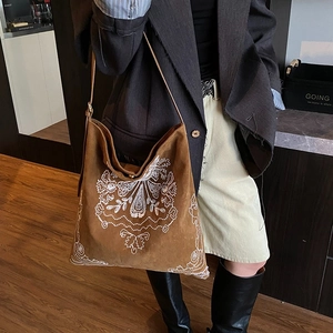 Vintage bohemian brown suede tote bag with intricate white floral embroidery and shoulder strap
