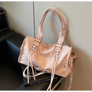 Détail du sac cabas rose clair avec poignées renforcées, rivets en métal et cordes tissées